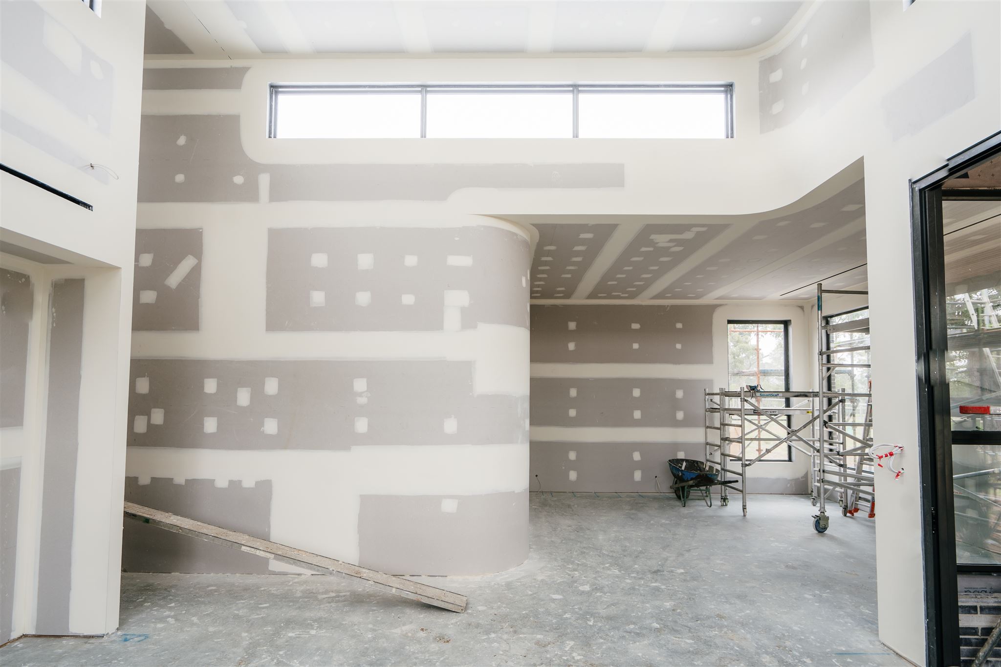 Curved plasterboard wall and bulkhead with set joints beneath highlight windows